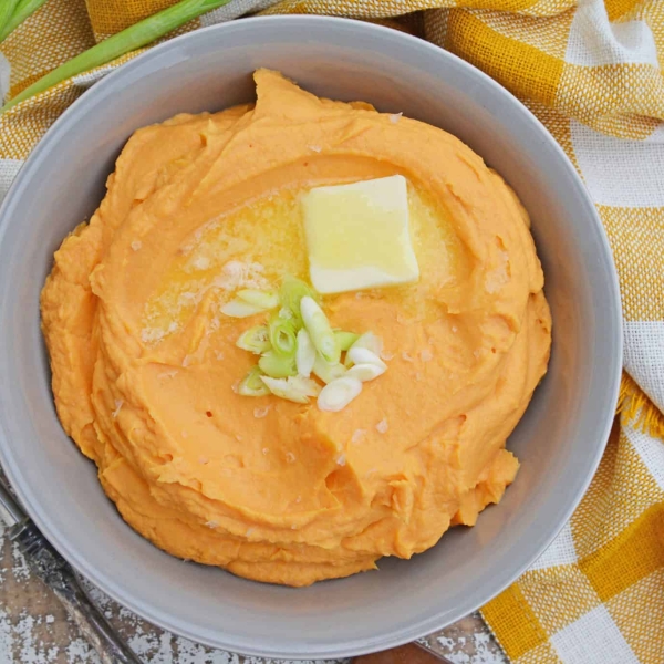 This Mashed Sweet Potatoes recipe uses baked sweet potatoes with natural sugars, bay leaf infused cream and a spike of orange juice for the best sweet potato mash ever! #sweetpotatomash #mashedsweetpotatoes www.savoryexperiments.com