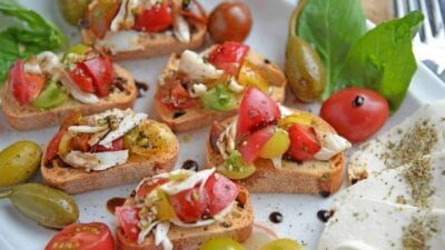 Crab Bruschetta is a mound of fresh tomatoes, garlic basil and buttery crab meat piled high on crispy toast. This is one of the best appetizers out there! #crabbruschetta #easybruschetta www.savoryexperiments.com