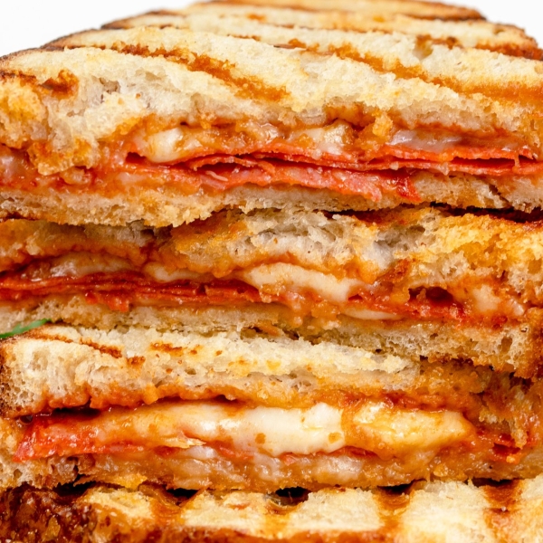 close up of a pizza sandwich cut and piled