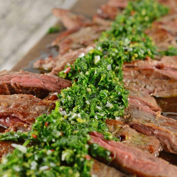 Skirt Steak Chimichurri is a grilled steak recipe that'll leave you drooling! Easy to make and topped with a delicious chimichurri sauce. #whatisskirtsteak #whatischimichurri #grilledsteakrecipe www.savoryexperiments.com