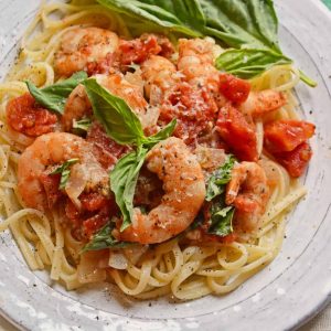 Tomato Basil Shrimp Pasta is an easy and healthy shrimp pasta recipe. It's great for busy weeknights but full of flavor and sure to impress guests! #shrimppasta #shrimpmeals #shrimppastarecipe www.savoryexperiments.com