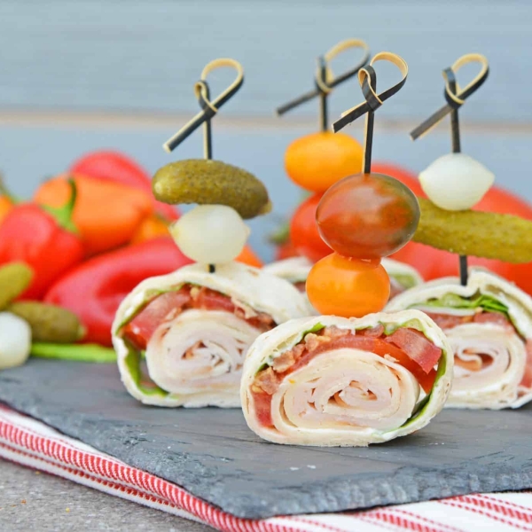 Turkey Club Sandwich Pinwheels use the traditional club sandwich ingredients, but wrap them in a tortilla. Easy to make, eat and clean up! #clubsandwichrecipe #turkeyclub #howtomakepinwheels www.savoryexperiments.com