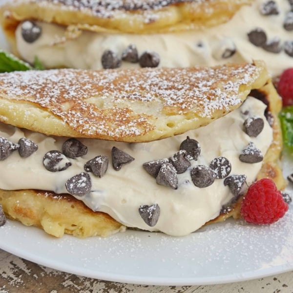 Cannoli Pancakes are stuffed with a rich, delicious cannoli filling. This breakfast cannoli is perfect for special breakfasts and brunches. #cannolipancakes #breakfastcannoli #cannolifilling www.savoryexperiments.com