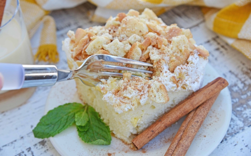 This Eggnog Poke Cake recipe is an easy pudding poke cake made with box cake mix and instant vanilla pudding, with delicious eggnog flavor. #pokecakerecipe #puddingpokecake #eggnogrecipes www.savoryexperiments.com