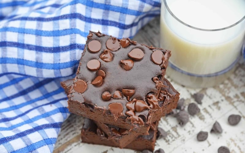 Stack of Flourless Black Bean Brownies with a glass of milk