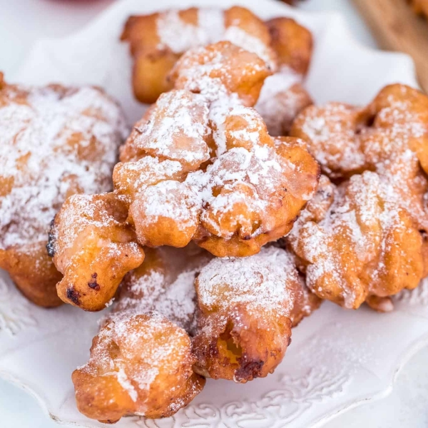 Crispy apple fritters on a white serving dish