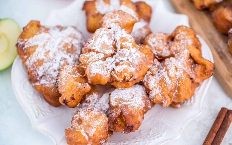 Crispy apple fritters on a white serving dish