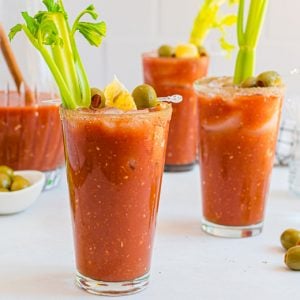 three glasses of bloody mary with garnish