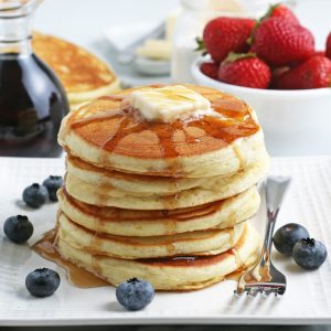 stack of DIY pancakes with fruit and syrup