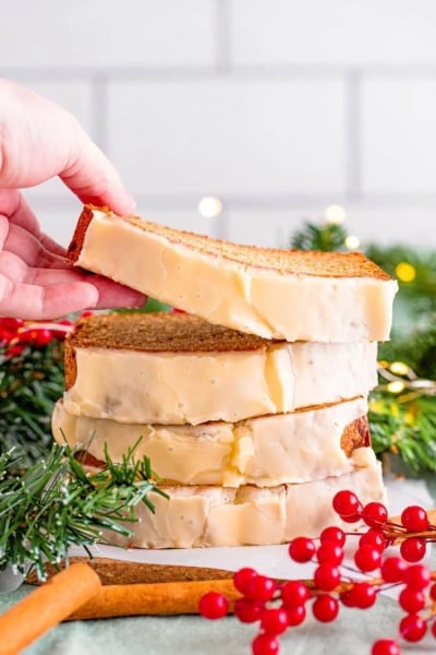 hand grabbing slice of eggnog bread