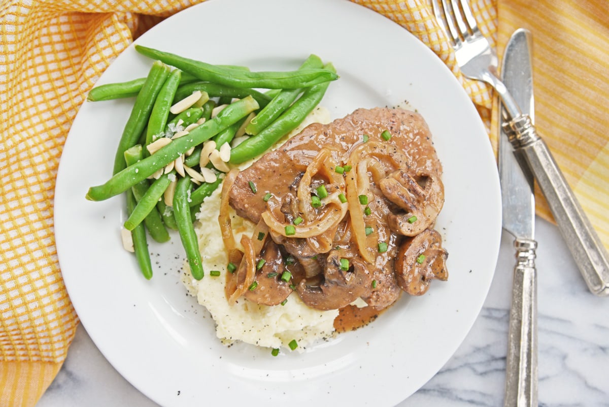 overhead of cube steak with gravy and green beans  