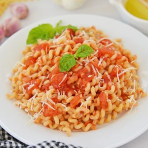 close up of pomodoro sauce over pasta in a bowl