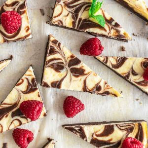 cut cream cheese brownies with fresh raspberries