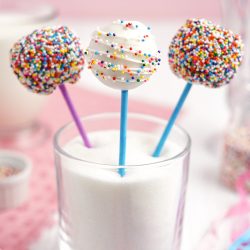 angled shot of three cake pops in a glass