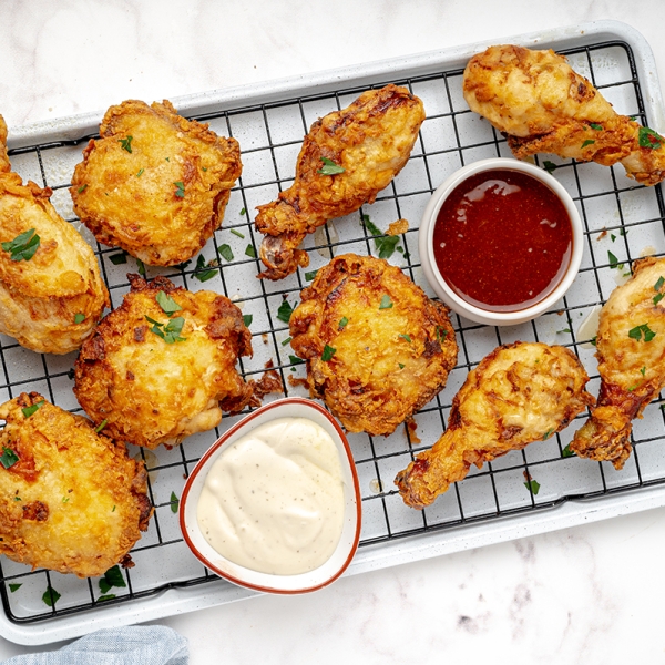 buttermilk fried chicken on wire rack with hot sauce tilted