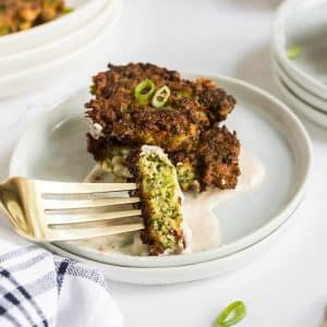 bite of broccoli fritters dipping into sauce