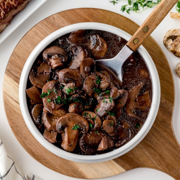 overhead of a spoon in a bowl of mushrooms