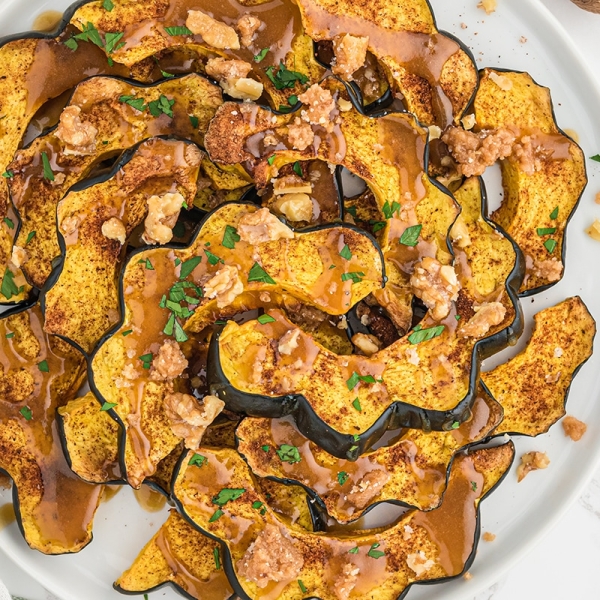 overhead of baked acorn squash with maple sauce and candied walnuts