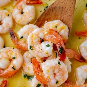 brined shrimp in a pan with a wooden spoon