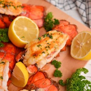 close up of a lobster tail with lemons and parsley