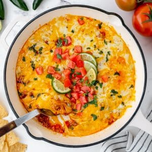 overhead shot of spoon in skillet of chorizo queso fundido