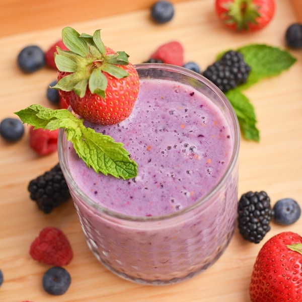 angled shot of glass of berry smoothie