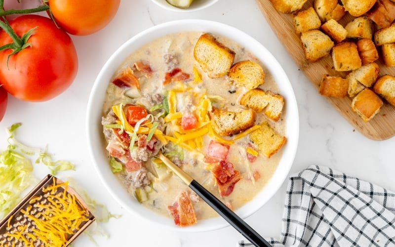 overhead shot of cheeseburger soup with spoon in bowl