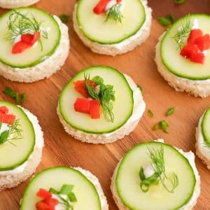 close up angled shot of cucumber sandwiches on a board