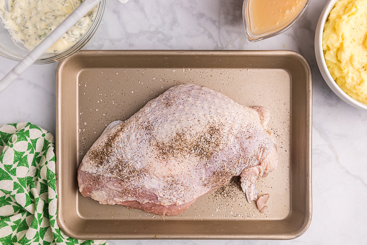overhead shot of raw turkey breast on baking sheet