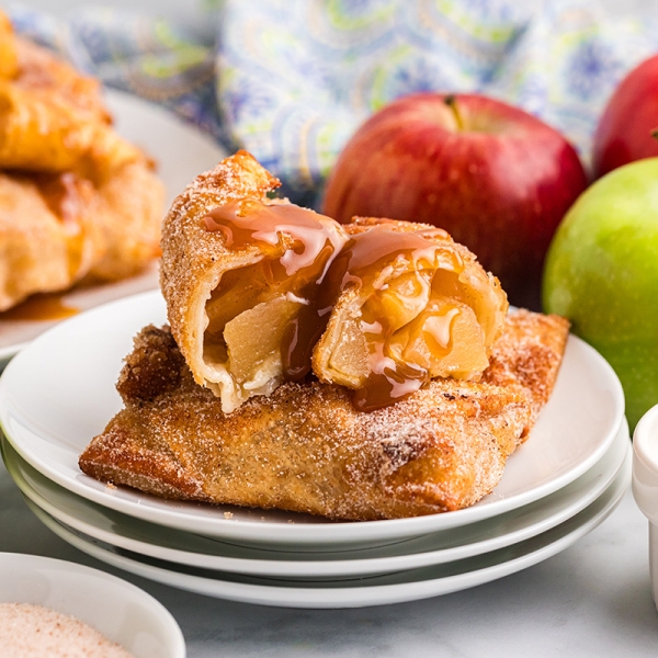 straight on shot of apple pie egg roll cut in half on plate