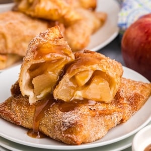 close up straight on shot of apple pie egg roll cut in half on plate