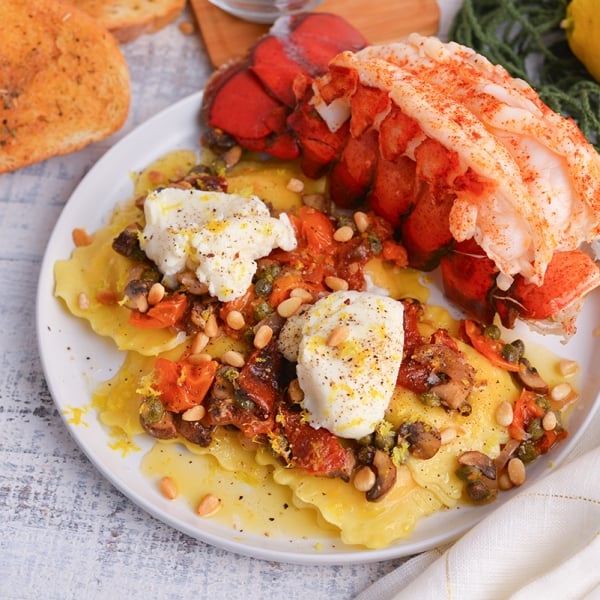 angled shot of mediterranean lobster ravioli on plate with lobster tail