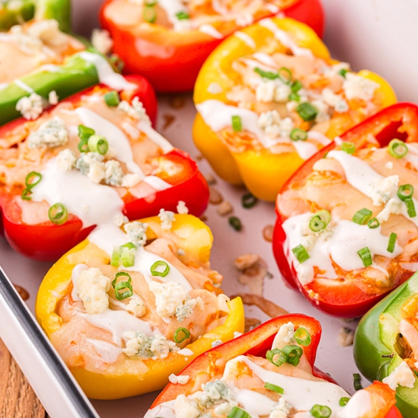 angled shot of buffalo chicken stuffed peppers in baking dish