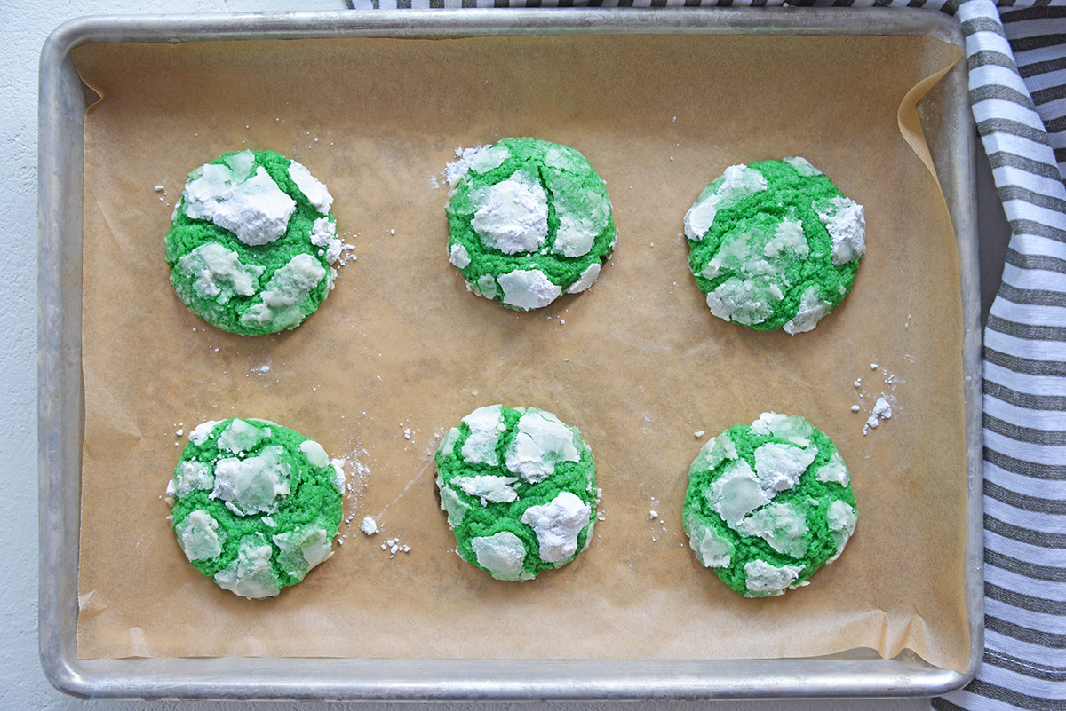 overhead shot of green mint crinkle cookies on sheet pan