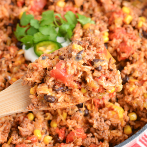 overhead shot of wooden spoon in pan of mexican ground beef casserole