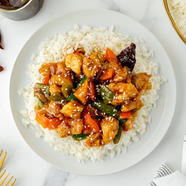 overhead shot of szechuan chicken over rice on a plate