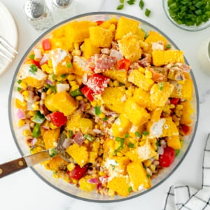 overhead shot of serving spoon in bowl of cornbread salad