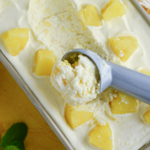 close up of scoop of homemade no churn ice cream with pineapple chunks