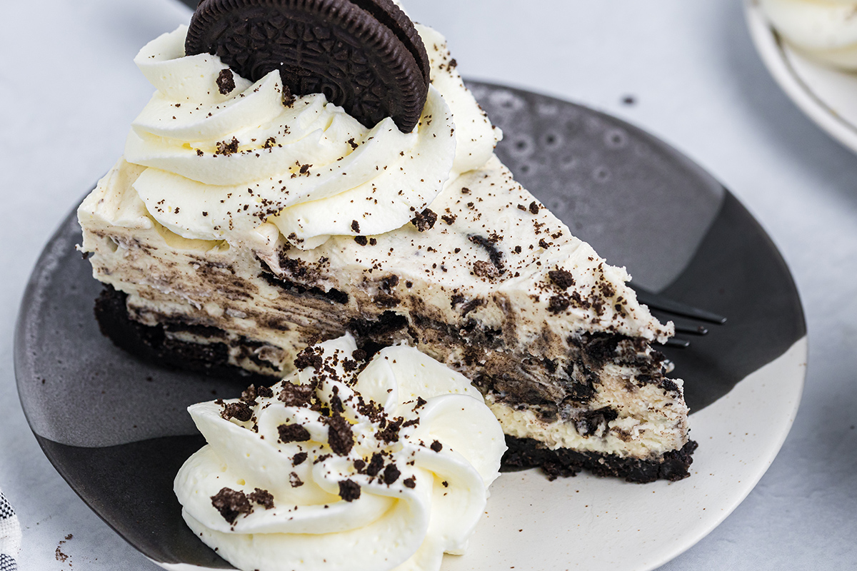 close up overhead angled shot of slice of oreo cheesecake on plate