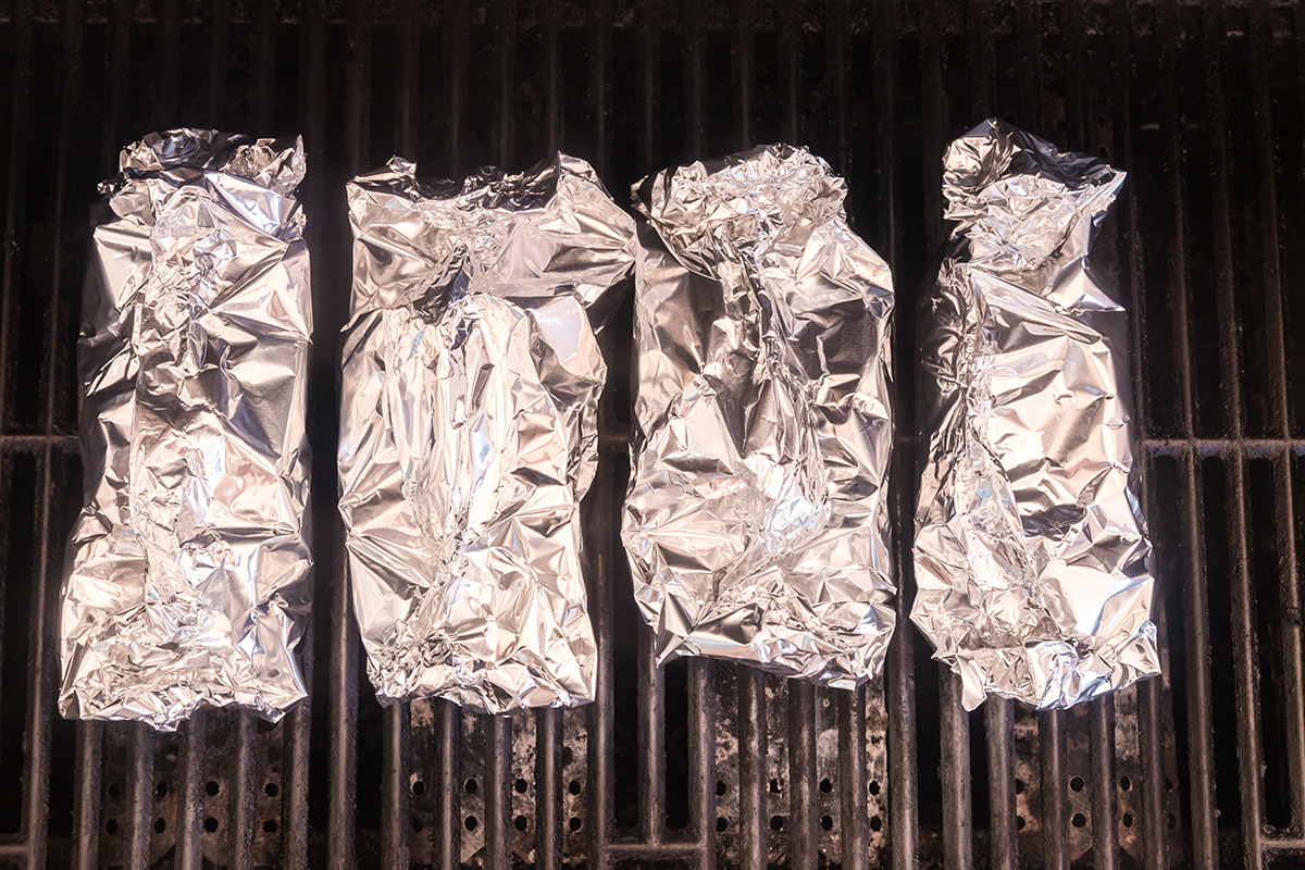 overhead shot of chicken foil packets on the grill