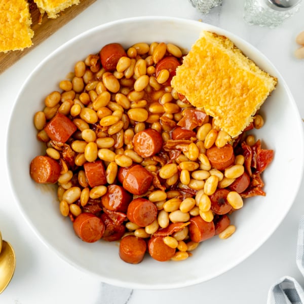 overhead shot of bowl of beanie weenies with cornbread