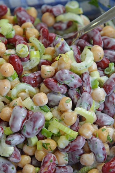 mixing beans together with yogurt, scallions and celery