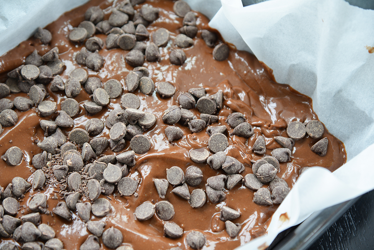 avocado brownie batter in a baking dish with chocolate chips