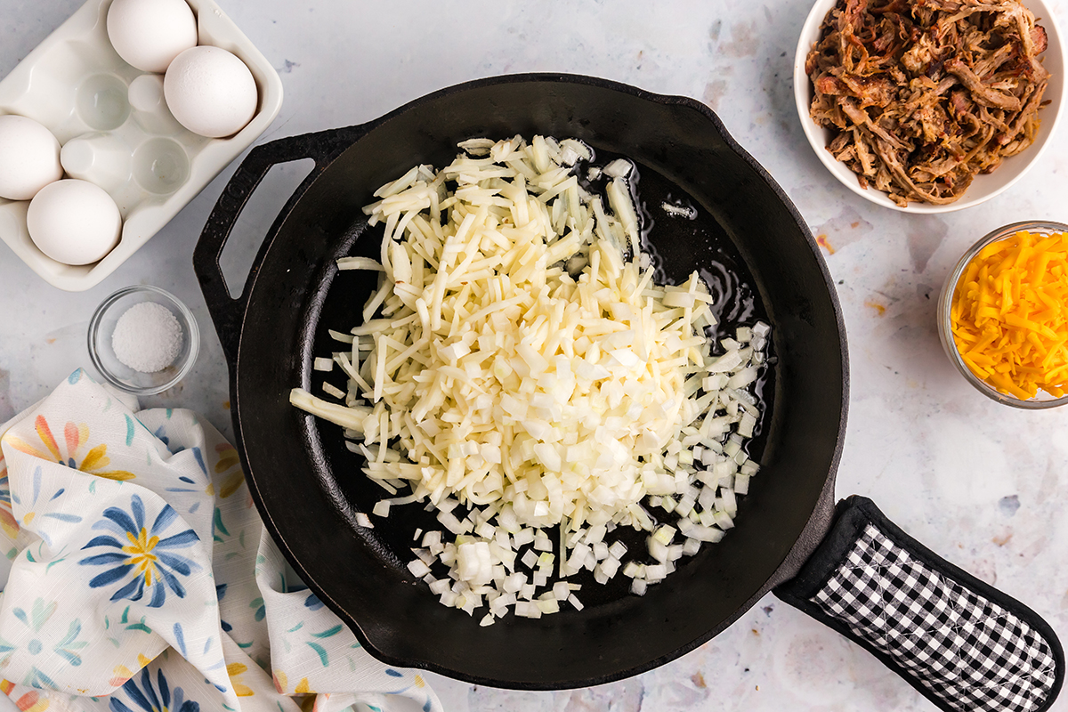 shredded potatoes and onion in skillet