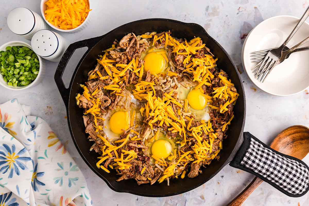 shredded cheese added to skillet with pork and eggs