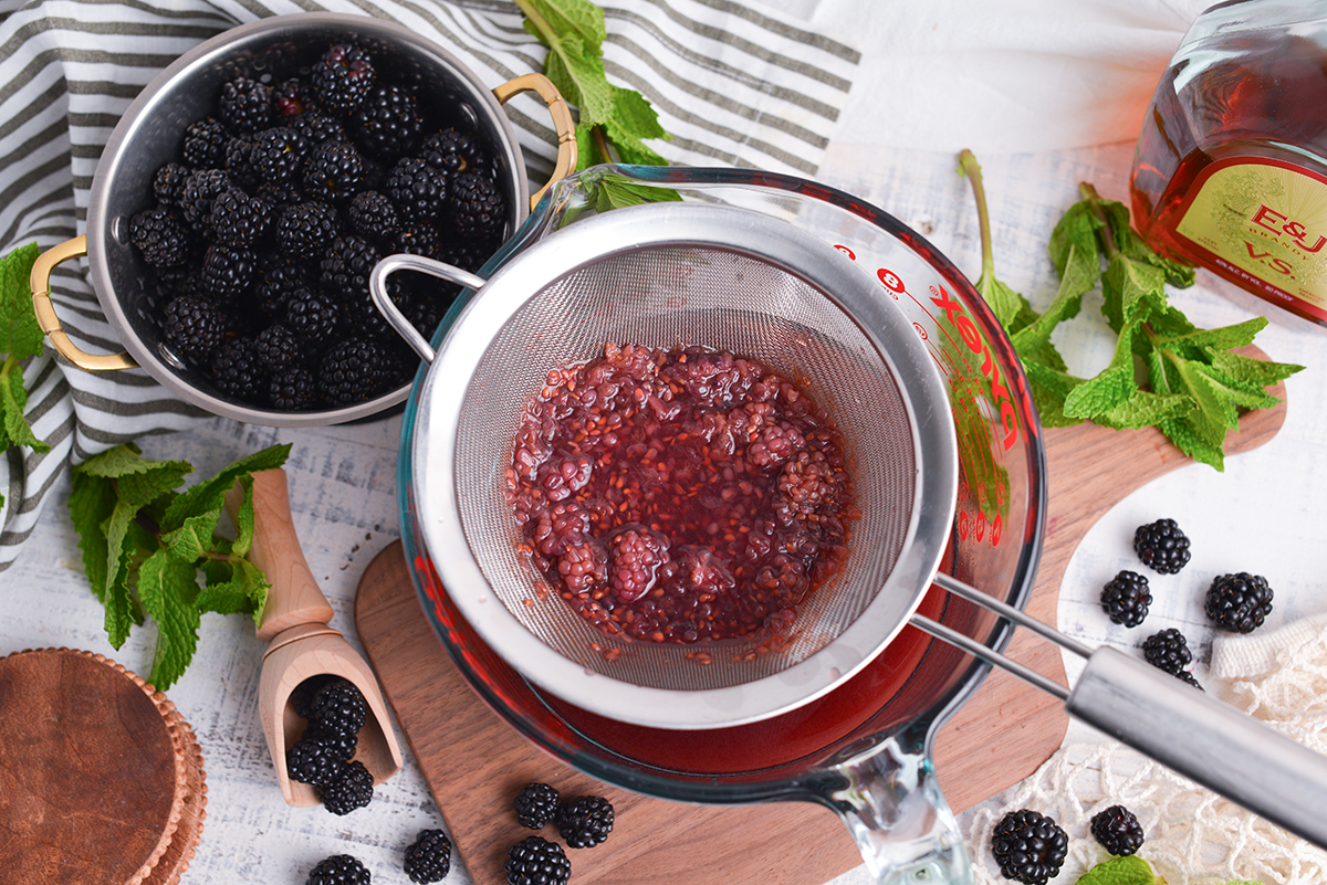 blackberries straining into measuring cup