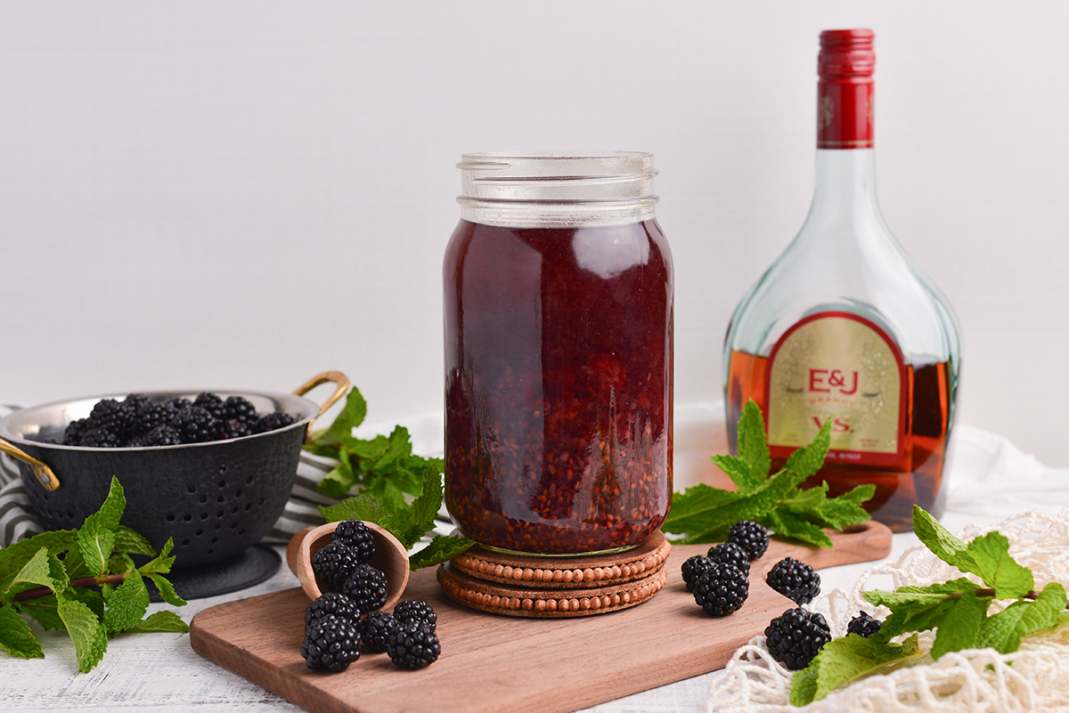 straight on shot of brandy and blackberries in jar