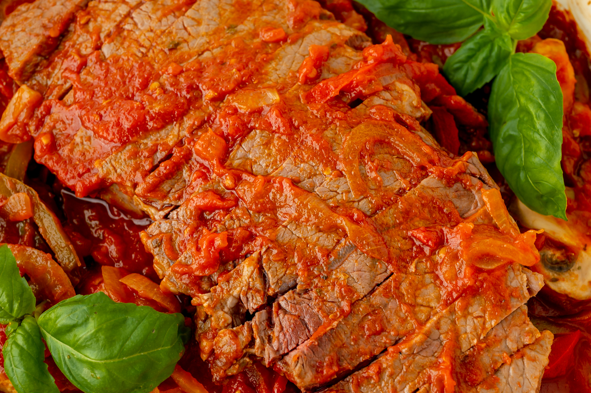 overhead shot of sliced steak coated in red sauce