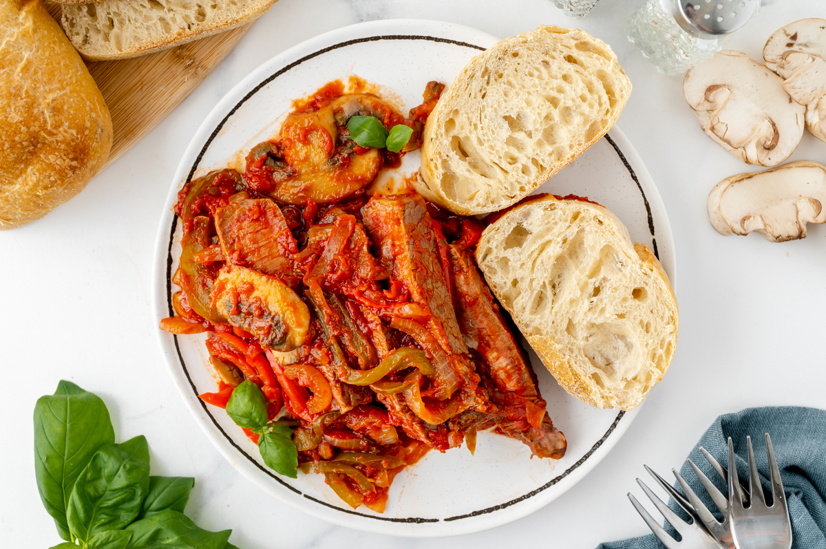 overhead shot of Carne alla Pizzaiola on plate with bread