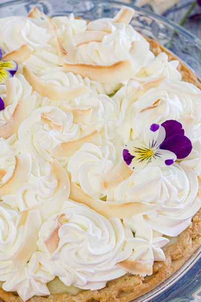 angle of coconut cream pie on blue table